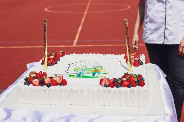 Tort urodzinowy na tle boiska.
