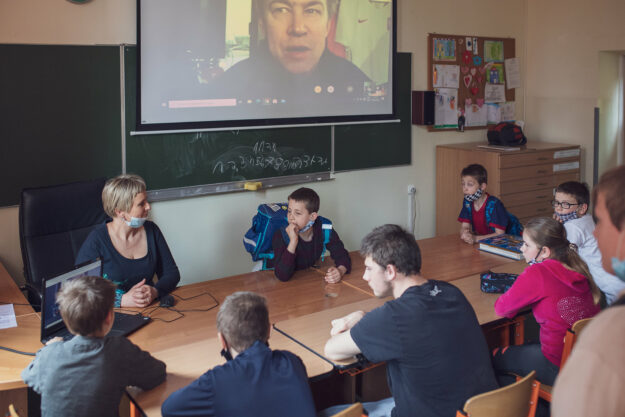 Uczniowie w klasie prowadzą rozmowę z Michałem Polem przez Internet