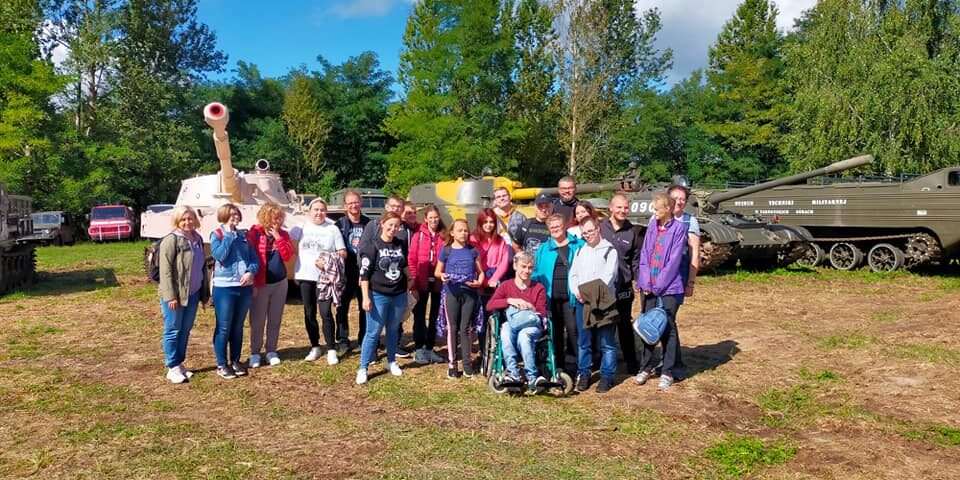 Uczniowie stoją na tle sprzętu wojskowego..