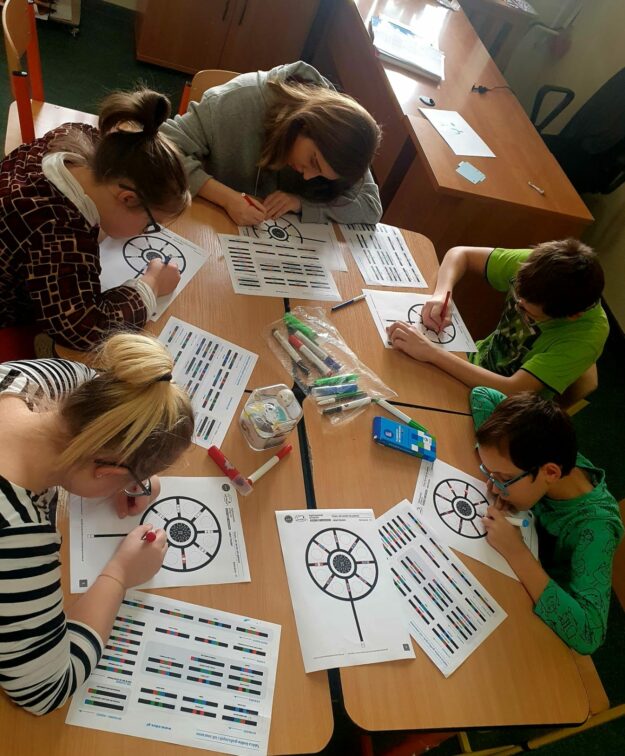 uczniowie programują drogę dla robota specjalnymi flamastrami