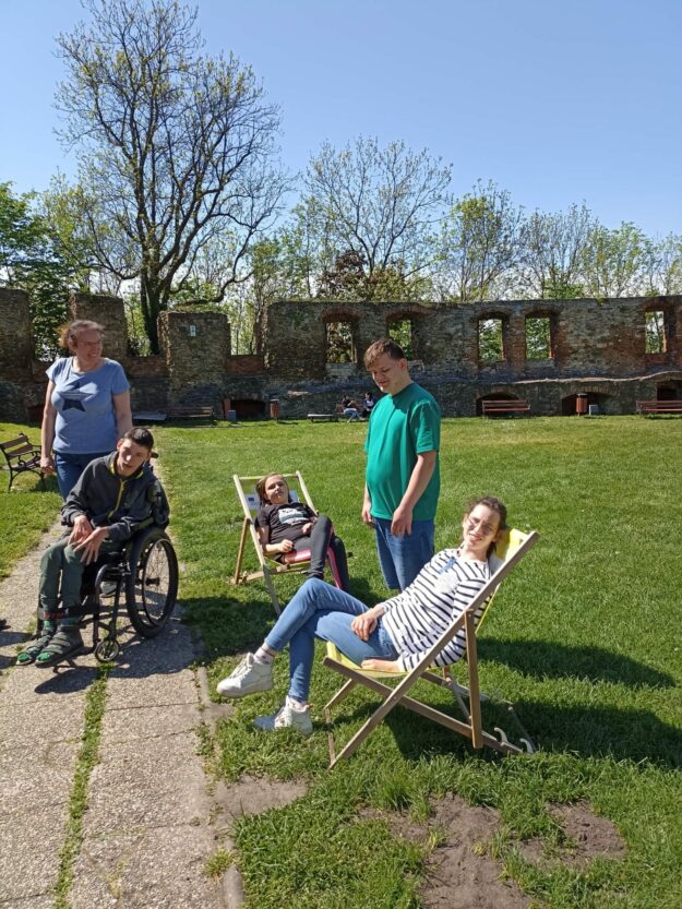 uczniowie siedzą na leżakach na dziedzińcu zamku