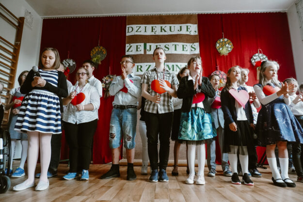 uczniowie występujący w akademii stoją na środku sali