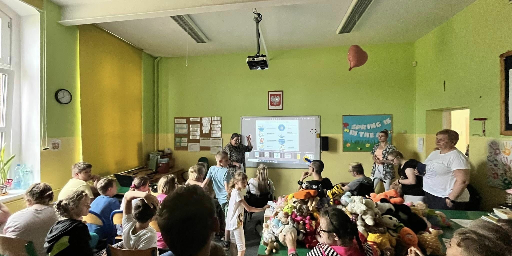 uczniowie w sali lekcyjnej słuchają referatu nauczyciela