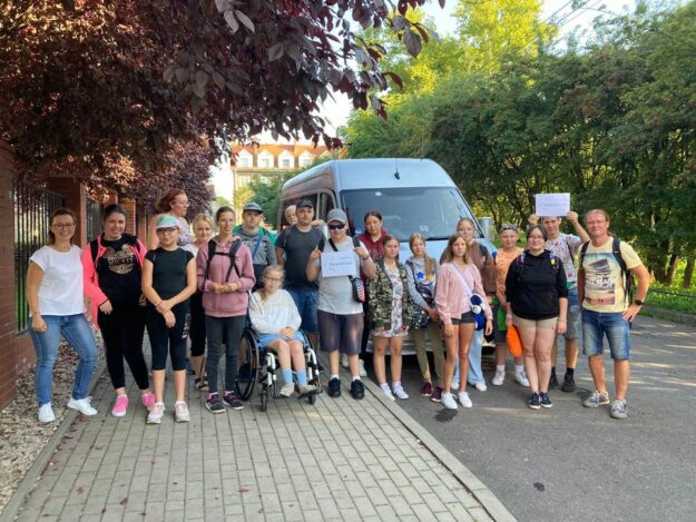 osoby wyjeżdżające na wycieczkę stoją przed busem