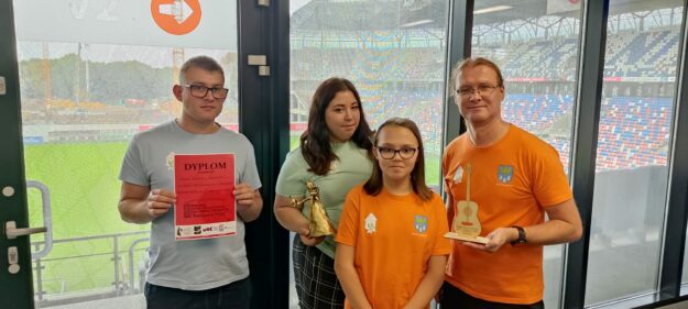 uczniowie wraz z nauczycielem prezentują odebrane nagrody