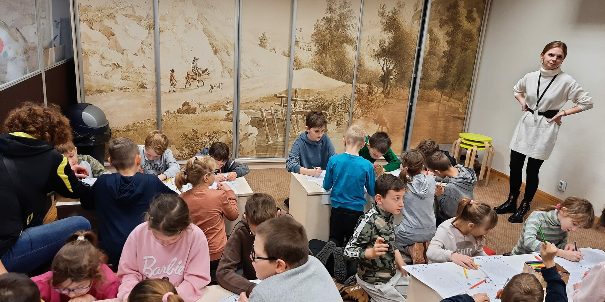 uczniowie przy stolikach wypełniają karty pracy