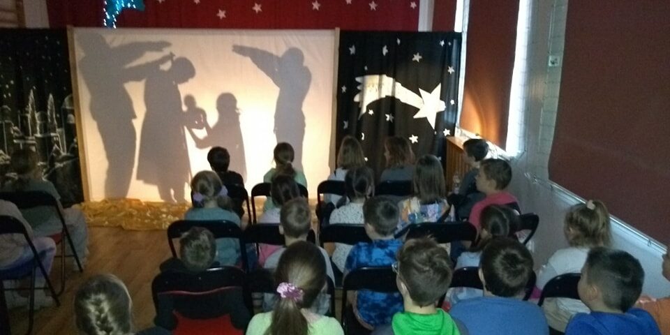 zaproszeni uczniowie oglądają jasełka w konwencji teatru cieni