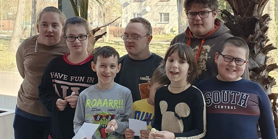 uczniowie na wspólnym zdjęciu na tle roślin