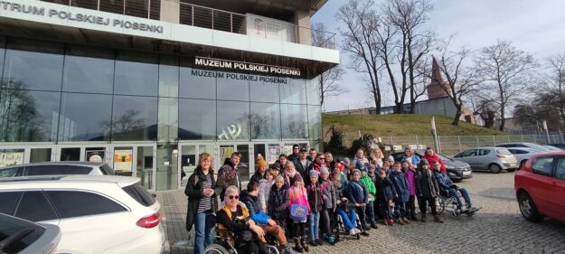 uczestnicy wycieczki stoją na tle budynku muzeum