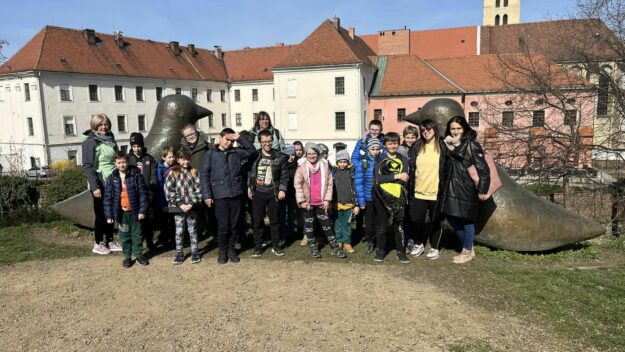 uczestnicy wyjazdu stoją na tle budynków Opavy