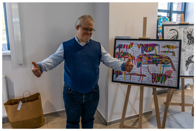 laureat stoi dumny przed swoim obrazem