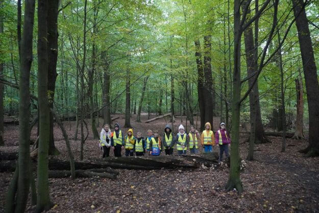 uczestnicy wycieczki stoją na dróżce leśnej