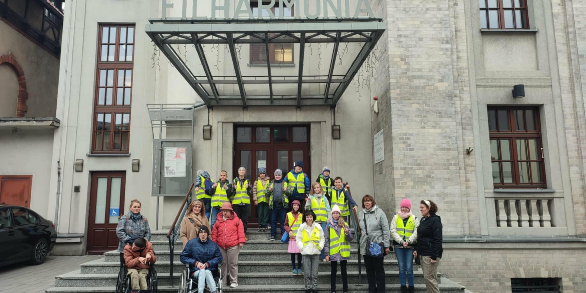 uczniowie wraz z opiekunami stoją przed wejściem do Filharmonii w Zabrzu