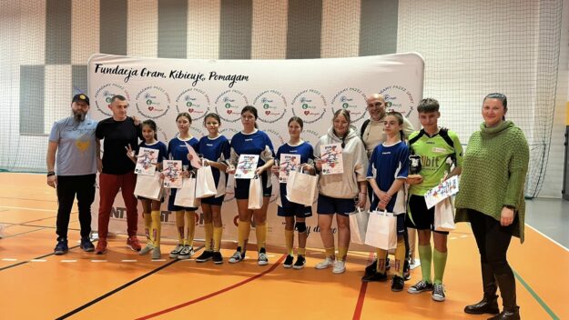 zawodnicy drużyny z dyplomami wraz z trenerem i organizatorami turnieju