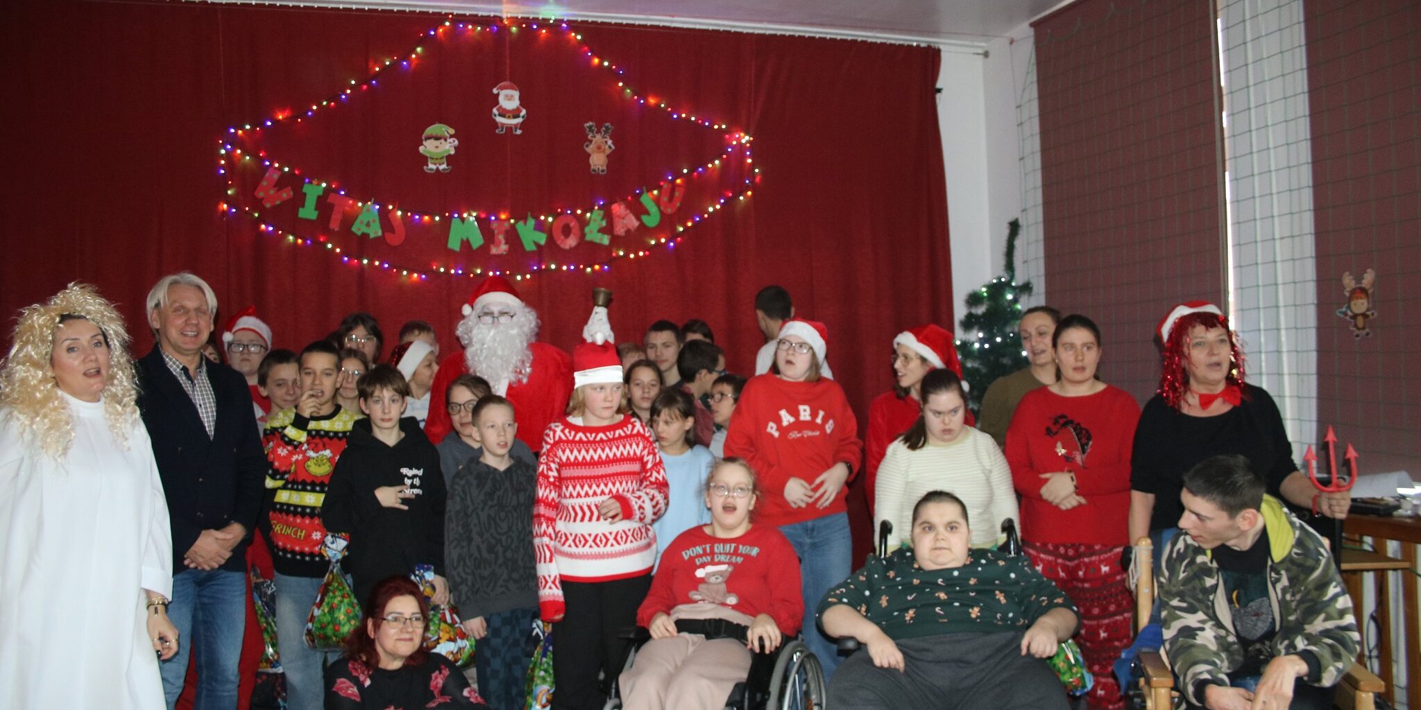 uczniowie wraz z dyrektorem szkoły, sponsorem i Mikołajem