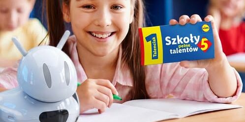 dziewczynka trzyma w ręku talon z napisem szkoły pełne talentów